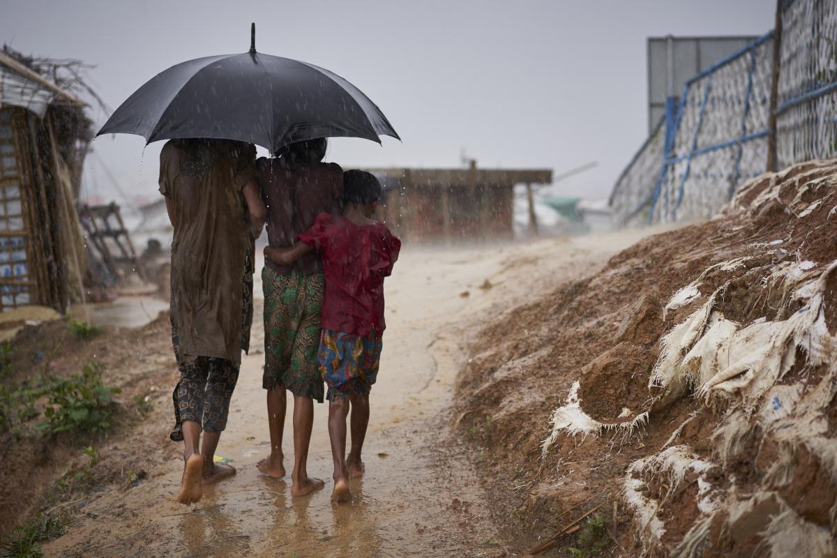 Des réfugiés rohingyas se frayent un chemin pendant une forte pluie de mousson dans le camp de Kutupalong. © UNHCR/David Azia
