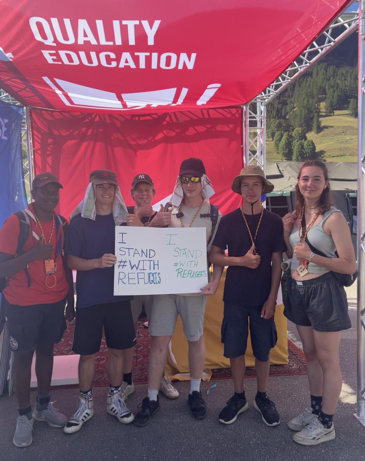 Un groupe de scouts européens tient fièrement une pancarte avec les mots 