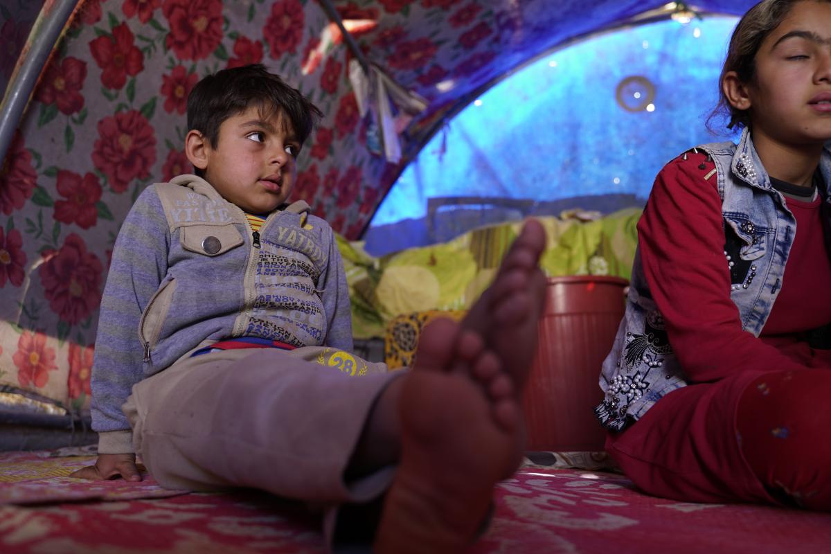 Her son watching Om Saker as she prepares dinner. © UNHCR/Ahmed Ayad