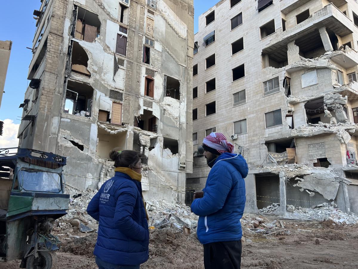 A staff member talks to a resident in the quake-affected district of Hama, Syria. © UNHCR
