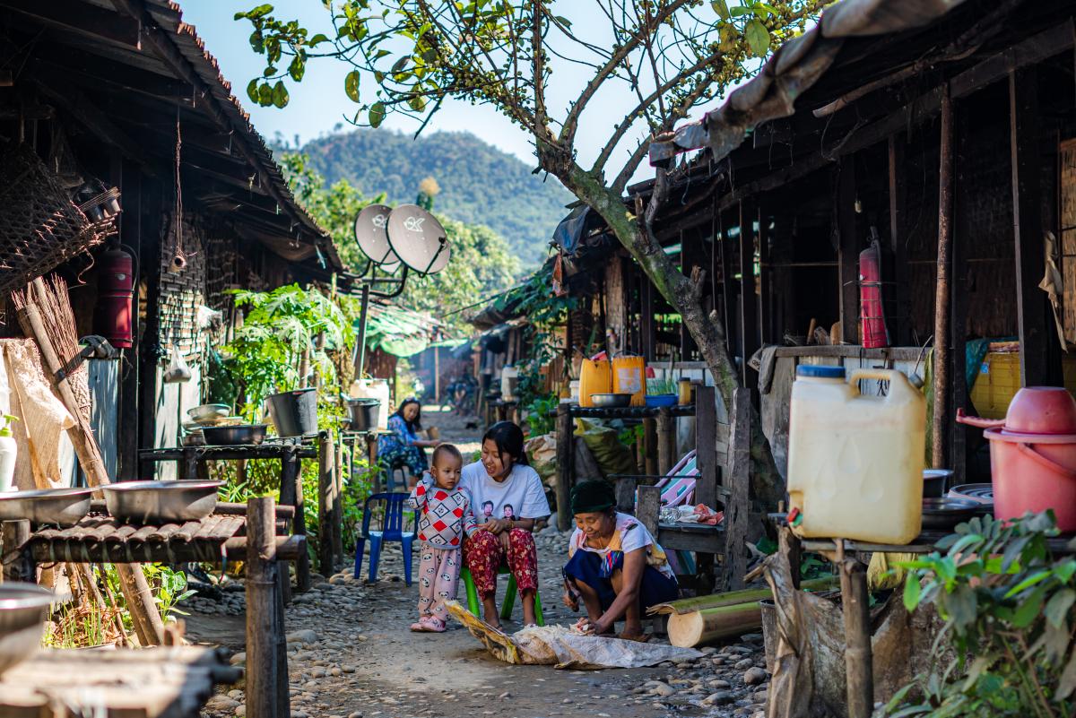 Daily life in an IDP camp. A woman is preparing food to feed her pigs in Kachin State. © UNHCR/Dumhpau Hkunring