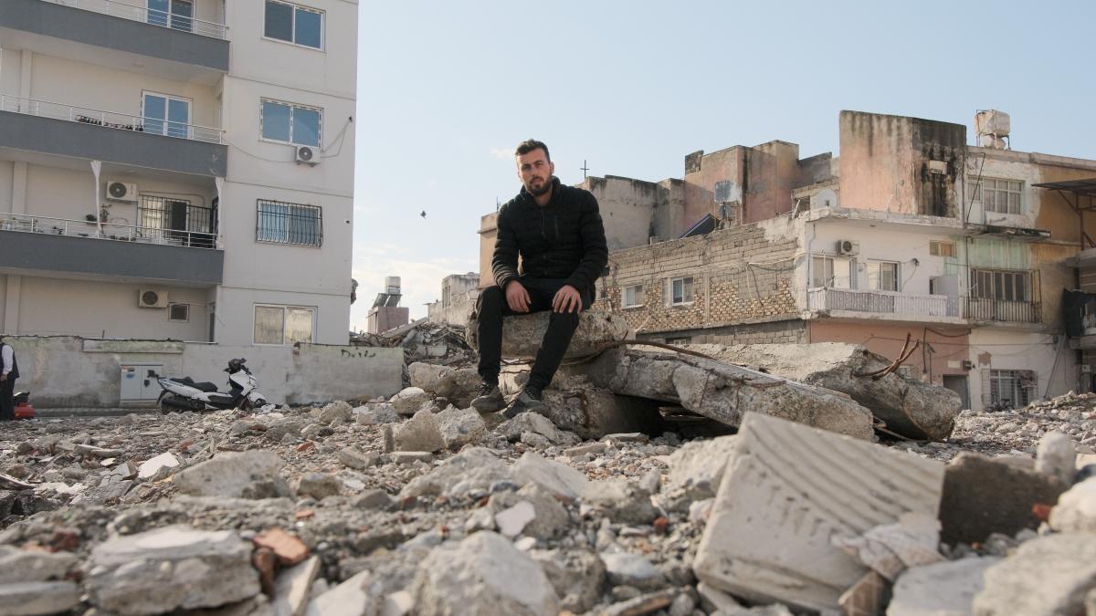 Syrian earthquake survivor Youssef Matrewawi in front of a destroyed building in Türkiye.