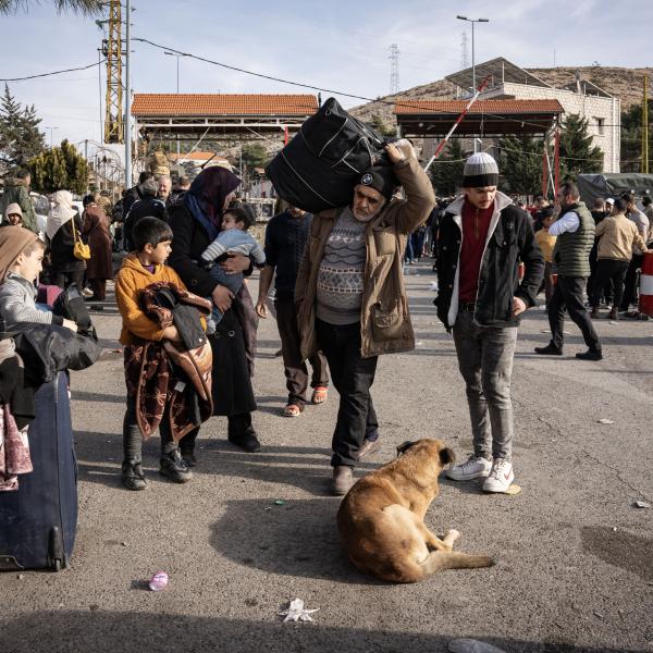 Families carrying their belongings as they prepare to enter Syria from Lebanon's Masnaa border crossing.UNHCR/Ximena Borrazas